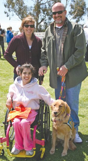 Clockwise from top left, Dawn and Kenneth Dietz and Bridget Dietz share a moment with Blossom from Canine Companions for Independence, in Balboa Park. Balboa Barks raised $32,000 for assistance dogs.