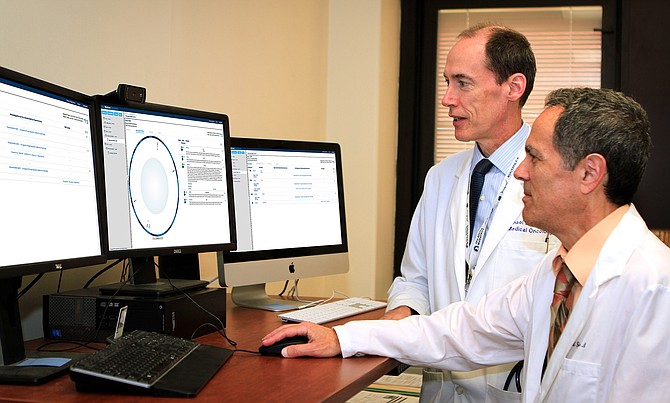 VA oncologists Michael Kelley (left) and Neil Spector review a Watson for Genomics DNA analysis report. Photo courtesy of IBM.