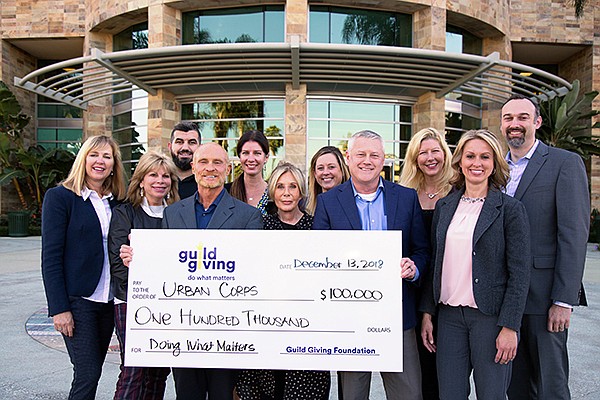 Terry Schmidt, left, Mary Ann McGarry, Marcel Oraha, Dan Thomas, Jennifer Graf, Anne Bernstein, Amber Elwell, Dave Robertson, Carolyn Frank, Kriselle Crane and Kevin Biddick, executives with Guild Mortgage and Urban Corps San Diego County celebrate a recent donation. Photo courtesy of Guild Mortgage