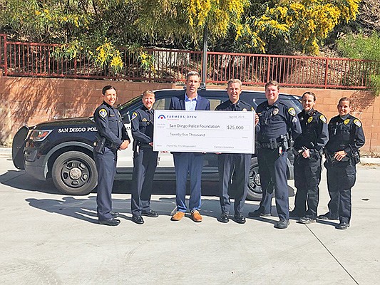 Henry Nembach of Sempra Energy and Assistant Chief Paul Connelly joined by members of the San Diego Police Department at a Farmers Insurance check presentation. Photo courtesy of Farmers Insurance