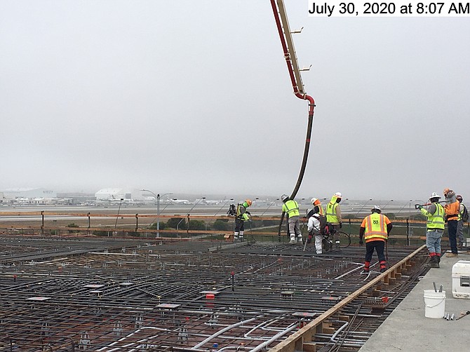 Werkers voltooien de laatste betonstorting op een LAX-parkeerplaats.