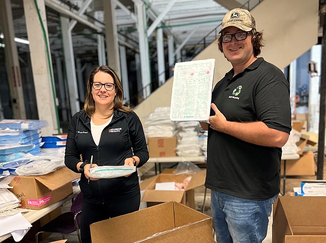 Heather Woodling, director of supply chain services at Palomar Health, packs surgical and trauma kits at the SSUBI warehouse with Baron Luxemburg of SSUBI. (Photo courtesy of Palomar Health)