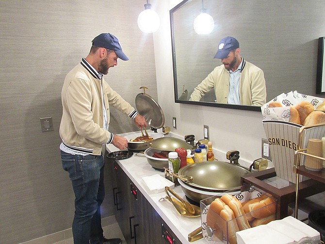 La Jolla resident Ken St. Pierre gets some food at the induction cooking area inside one of the newly renovated luxury suites at the April 18 Padres game at Petco Park. Photo by Karen Pearlman
