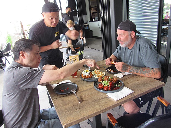 Cross Street Chicken and Beer co-founder Tommy Nguyen with diners Henry Casey Kawczynski (left) and Henry Diep at the Del Mar Highlands location. Photo by Karen Pearlman